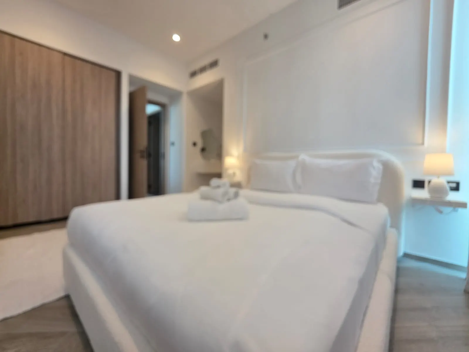 Bedroom with bespoke bed and wooden wardrobe